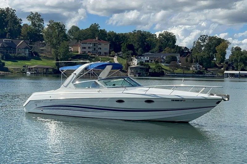 Slide: The Image of 2004 Formula 330 Sun Sport boat on a serene lake with scenic background. - 101