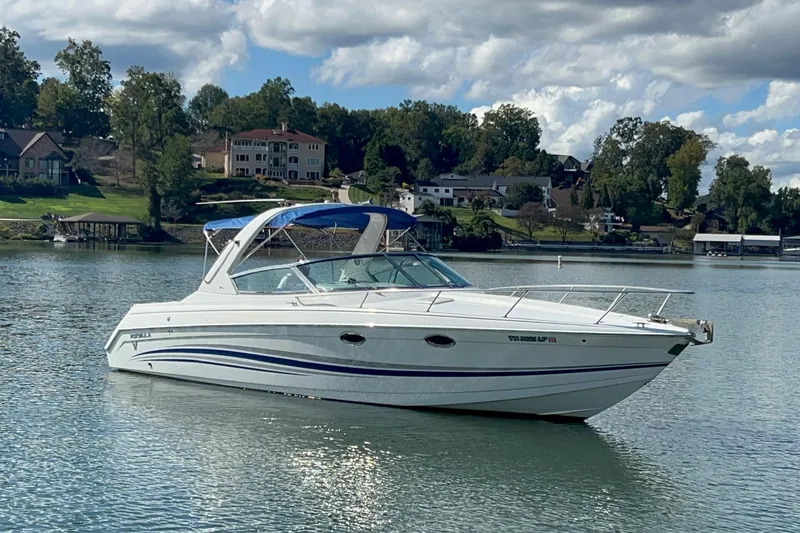 Slide: The Image of 2004 Formula 330 Sun Sport boat on a serene lake with houses in the background. - 104