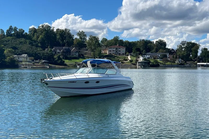 Slide: The Image of 2004 Formula 330 Sun Sport boat on a serene lake with scenic background. - 109