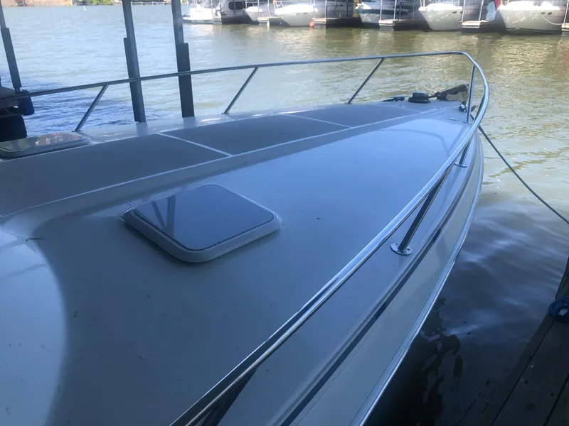 Slide: The Image of 2004 Formula 330 Sun Sport boat docked, showcasing sleek deck design and railing. - 14