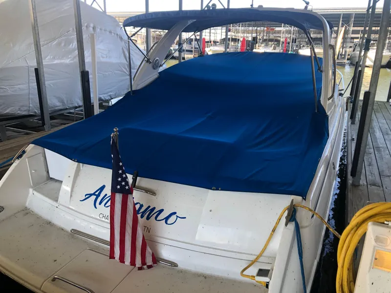Slide: The Image of 2004 Formula 330 Sun Sport boat docked with blue cover and American flag. - 3
