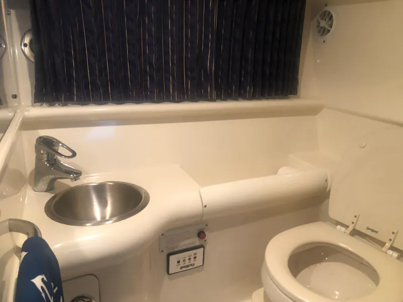 Slide: The Image of 2004 Formula 330 Sun Sport boat bathroom with sink, toilet, and curtain. - 32