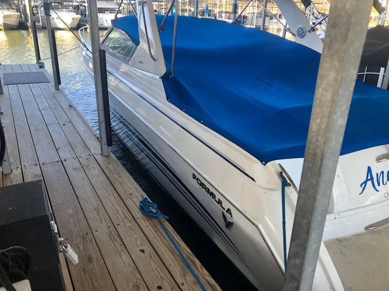 Slide: The Image of 2004 Formula 330 Sun Sport boat docked with blue cover. - 4