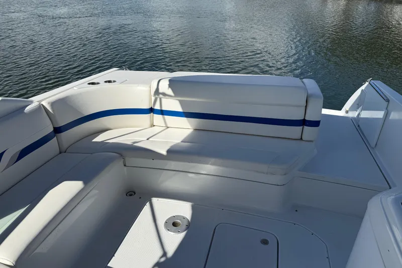 Slide: The Image of 2004 Formula 330 Sun Sport boat interior with white and blue seating by the water. - 65