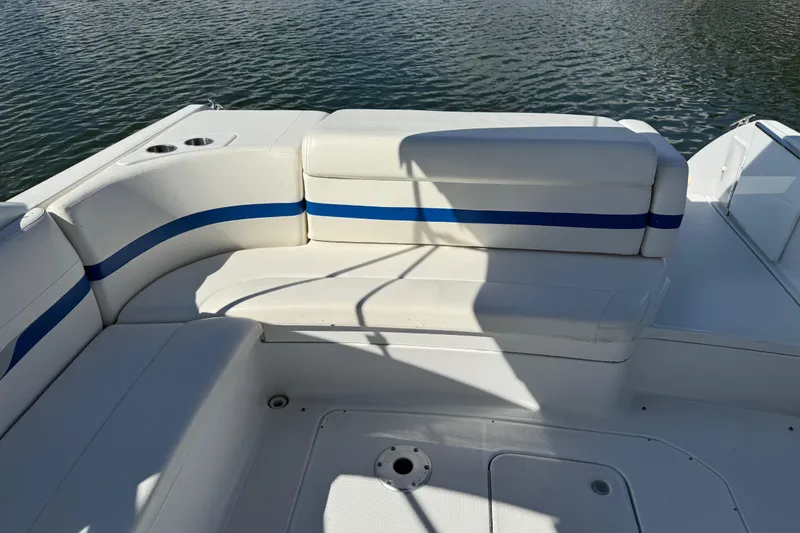 Slide: The Image of 2004 Formula 330 Sun Sport boat interior with white and blue seating by the water. - 68