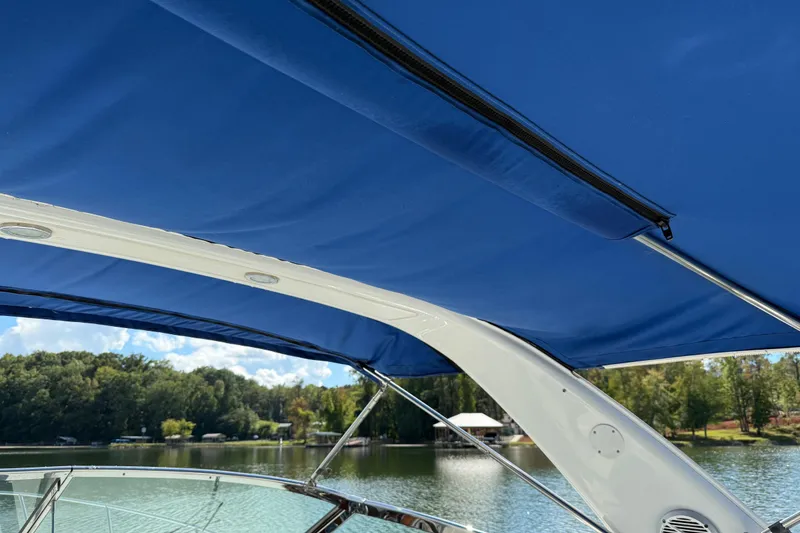Slide: The Image of 2004 Formula 330 Sun Sport boat with blue canopy on a serene lake. - 72