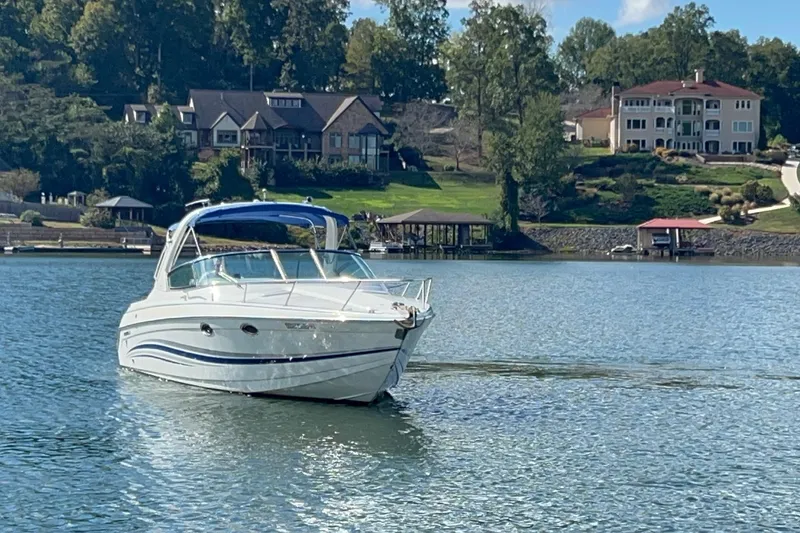 Slide: The Image of 2004 Formula 330 Sun Sport boat on a serene lake with luxury homes in the background. - 78
