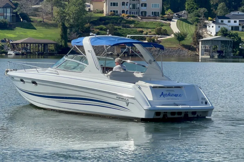 Slide: The Image of 2004 Formula 330 Sun Sport boat cruising on a serene lake with scenic background. - 86