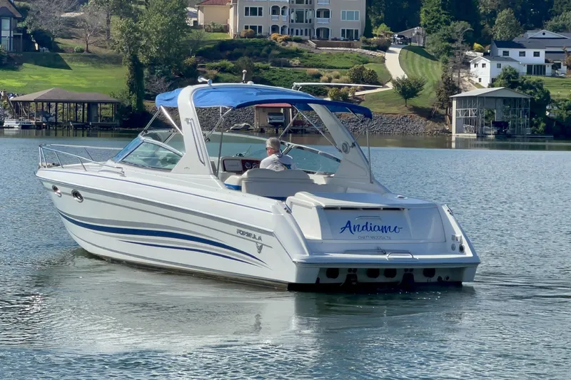 Slide: The Image of 2004 Formula 330 Sun Sport boat cruising on a serene lake with scenic background. - 87