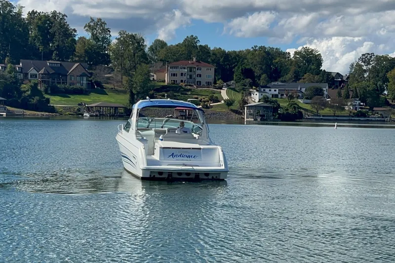 Slide: The Image of 2004 Formula 330 Sun Sport boat on a serene lake with houses in the background. - 91