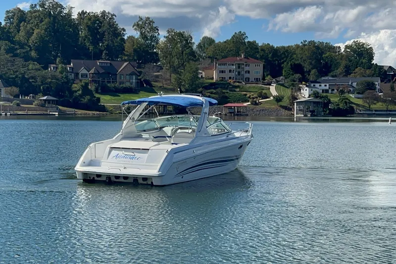 Slide: The Image of 2004 Formula 330 Sun Sport boat on a serene lake with scenic background. - 93