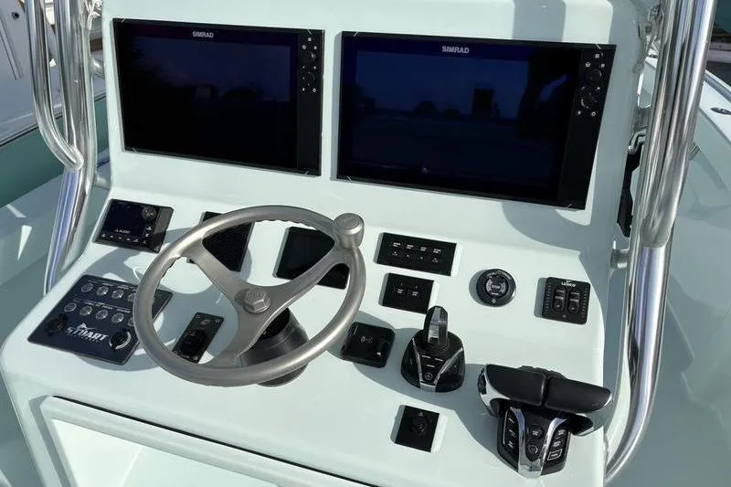 Slide: The Image of 2024 Stuart 27 boat helm with dual screens and controls. - 10
