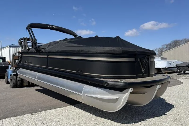 The Image of Viaggio x22u 2026 pontoon boat on trailer, black design, blue sky. - 0