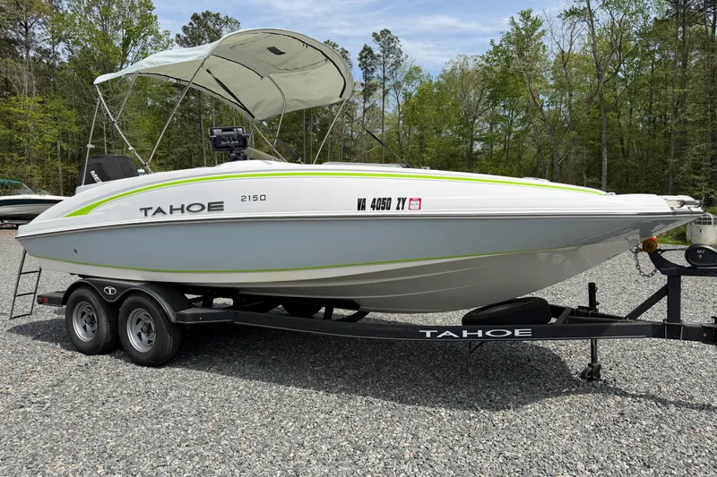 The Image of 2022 Tahoe 2150 boat on trailer, parked outdoors with trees in background. - 12