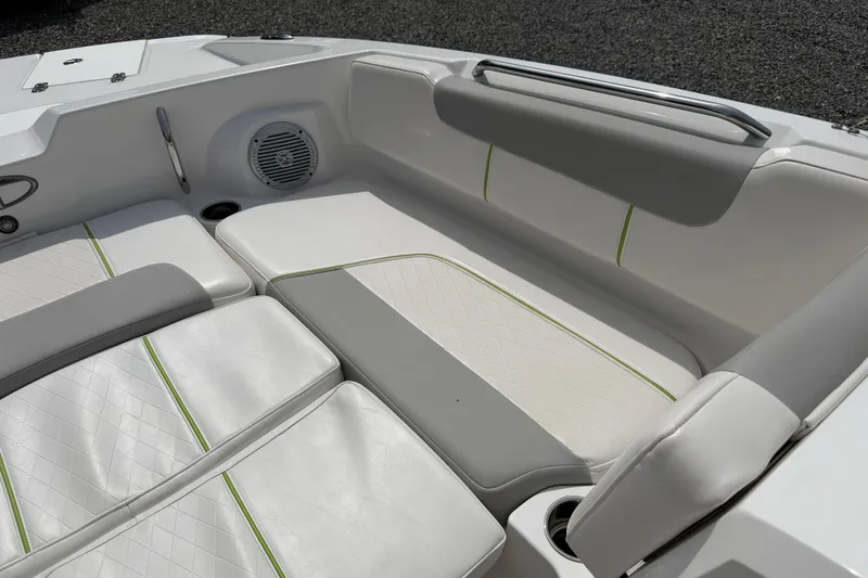 Slide: The Image of 2022 Tahoe 2150 boat interior with white and gray seating, green accents, and speaker. - 21