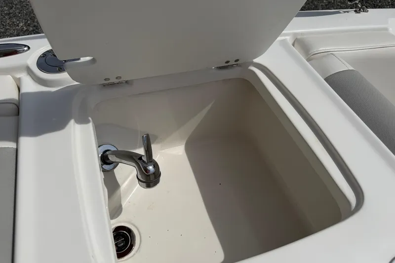 Slide: The Image of Open storage compartment with faucet on 2022 Tahoe 2150 boat. - 32