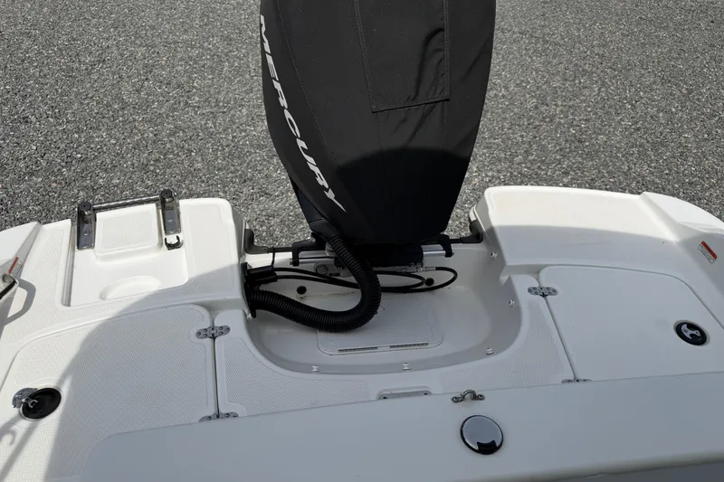 Slide: The Image of 2022 Tahoe 2150 boat stern with Mercury engine cover, white deck, and swim platform. - 34