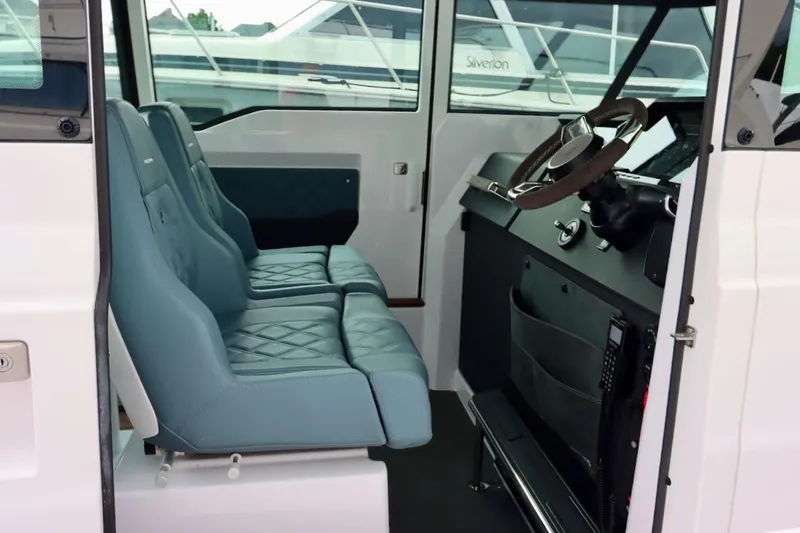 Slide: The Image of Interior of 2022 Axopar 37 XC Cross Cabin with blue seats and modern dashboard. - 10