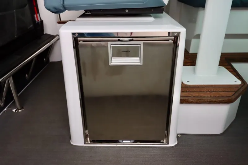 Slide: The Image of 2022 Axopar 37 XC Cross Cabin interior with compact stainless steel refrigerator. - 18