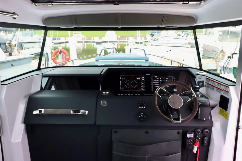 Slide: The Image of Interior view of 2022 Axopar 37 XC Cross Cabin helm with modern controls and steering wheel. - 19
