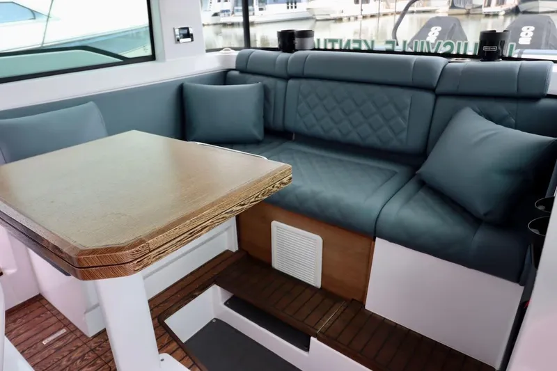 Slide: The Image of Luxurious interior of 2022 Axopar 37 XC Cross Cabin with plush seating and wooden table. - 21