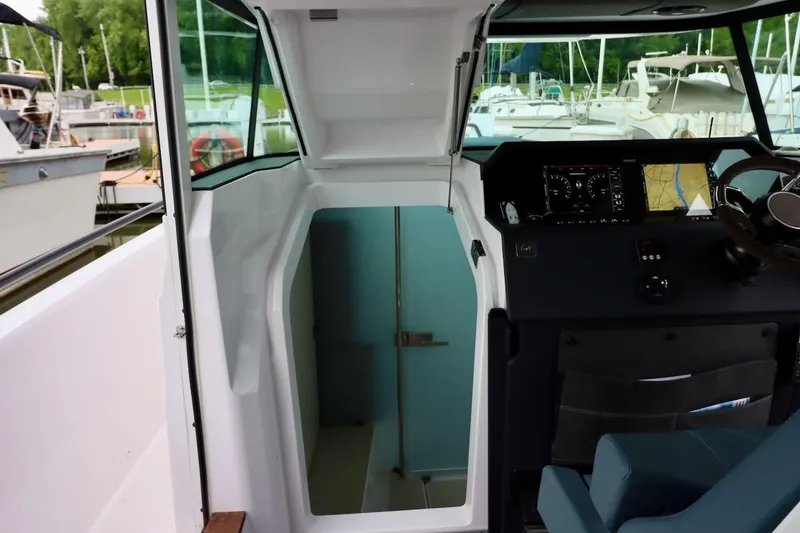 Slide: The Image of 2022 Axopar 37 XC Cross Cabin interior with helm and open cabin door. - 25
