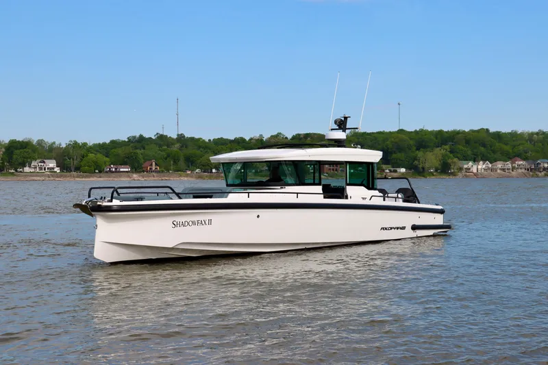 Slide: The Image of 2022 Axopar 37 XC Cross Cabin boat on a calm river with green shoreline. - 3