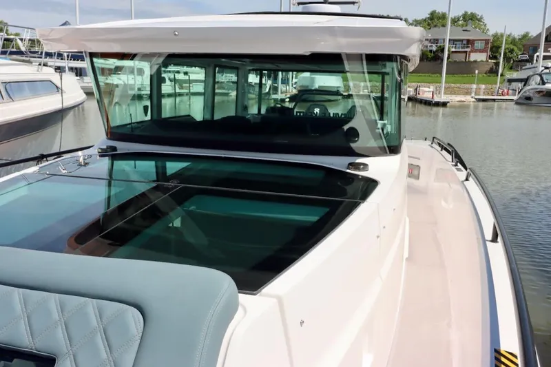 Slide: The Image of 2022 Axopar 37 XC Cross Cabin boat docked at marina, showcasing sleek design and spacious cabin. - 36