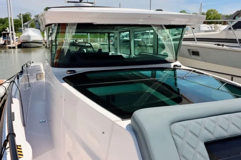 Slide: The Image of 2022 Axopar 37 XC Cross Cabin boat docked at marina, showcasing sleek design. - 37