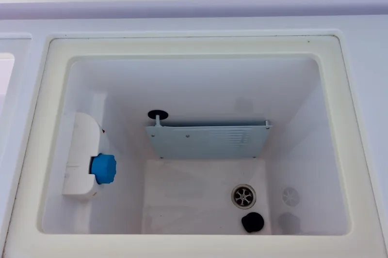 Slide: The Image of Interior compartment of 2022 Axopar 37 XC Cross Cabin boat, featuring drainage and storage elements. - 48