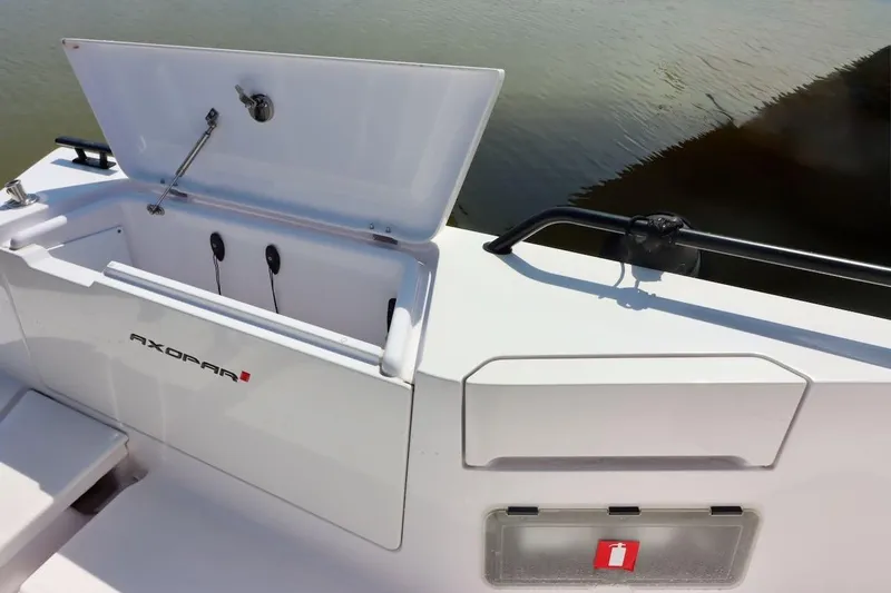 Slide: The Image of 2022 Axopar 37 XC Cross Cabin boat storage compartment open by the water. - 53