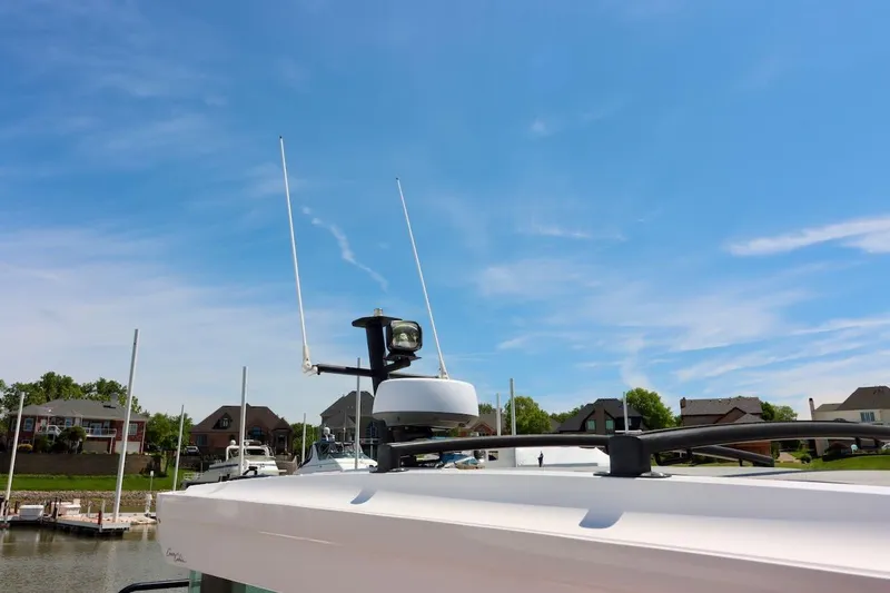 Slide: The Image of 2022 Axopar 37 XC Cross Cabin roof with antennas, under a clear blue sky. - 58