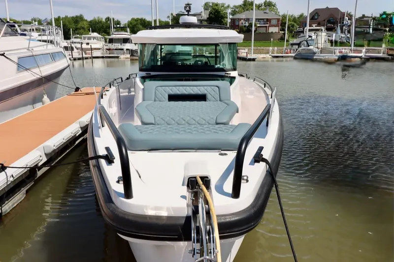 Slide: The Image of 2022 Axopar 37 XC Cross Cabin docked at marina, featuring spacious seating. - 8