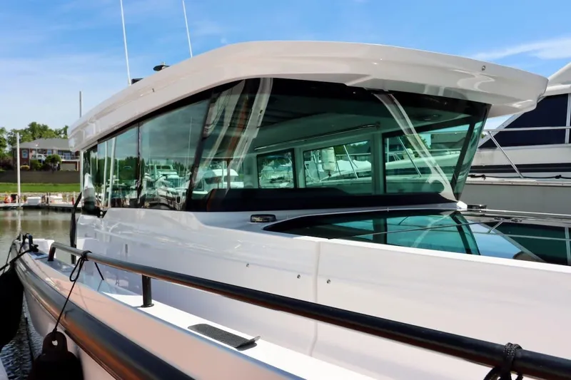 Slide: The Image of 2022 Axopar 37 XC Cross Cabin boat docked at marina under clear blue sky. - 9
