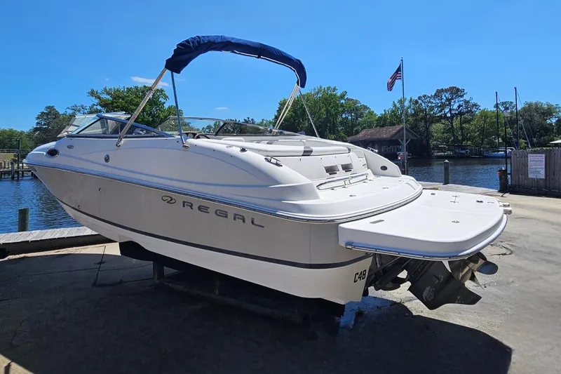 Slide: The Image of 2006 Regal 2400 Bowrider boat at dock with blue canopy. - 3