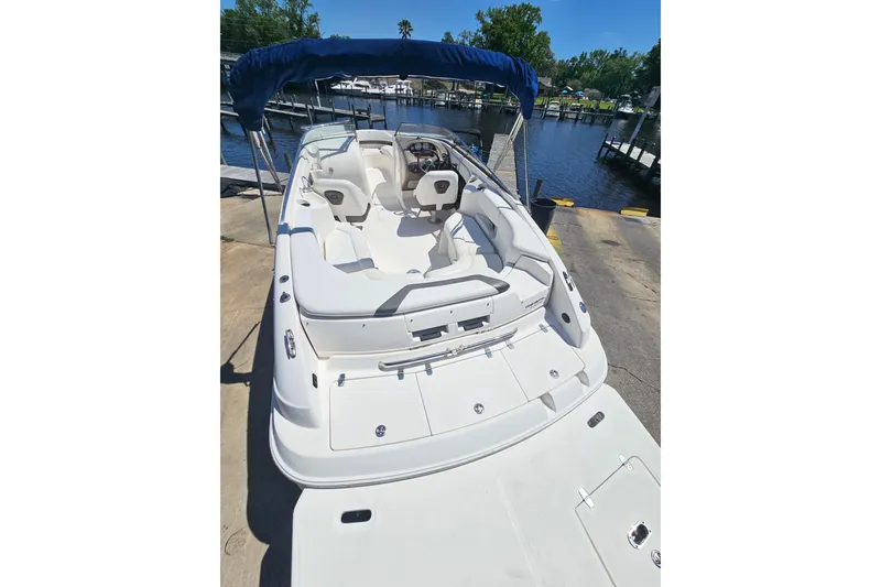 Slide: The Image of 2006 Regal 2400 Bowrider boat at dock with blue canopy. - 7