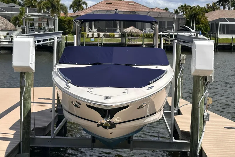 Slide: The Image of 2025 Regal LX6 boat docked in a sunny setting. - 2