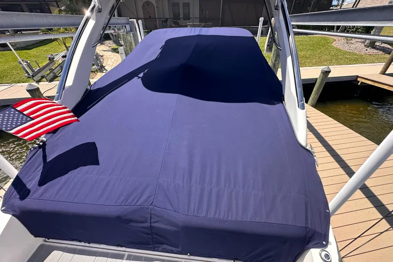 Slide: The Image of 2025 Regal LX6 boat with cover and American flag at dock. - 4