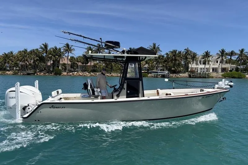 The Image of Stuart 27 boat 2025 on blue water with palm trees in background. - 1