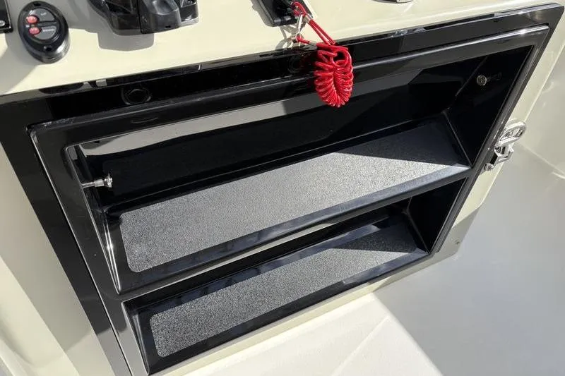 Slide: The Image of Stuart 27 boat console with storage and safety cord, model year 2025. - 28