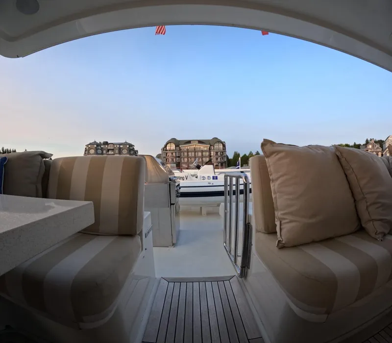 Slide: The Image of Luxury yacht Hargrave 93' (2007) with plush seating, docked at a scenic marina. - 16