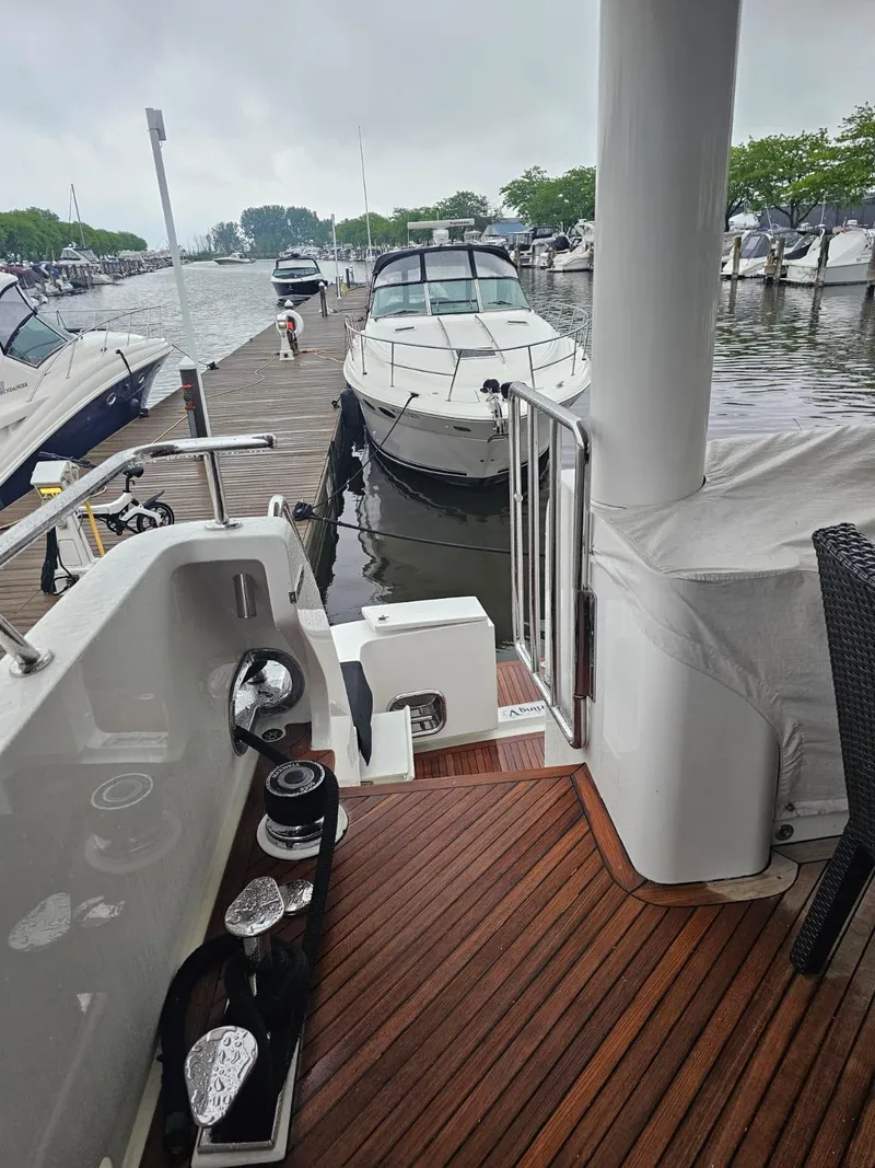 Slide: The Image of 2007 Hargrave 93' yacht docked at marina with wooden deck and nearby boats. - 19