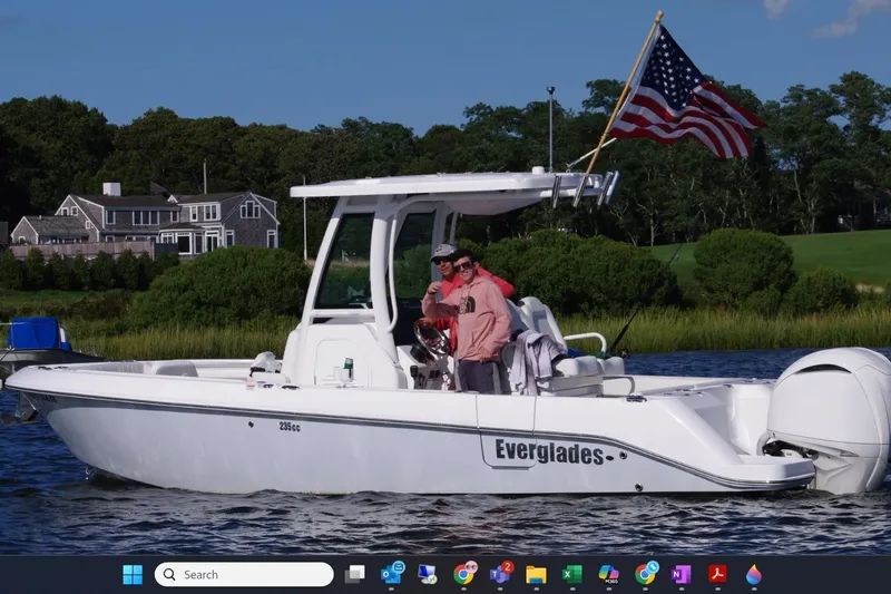 The Image of 2023 Everglades 235 Center Console boat on water with American flag. - 0