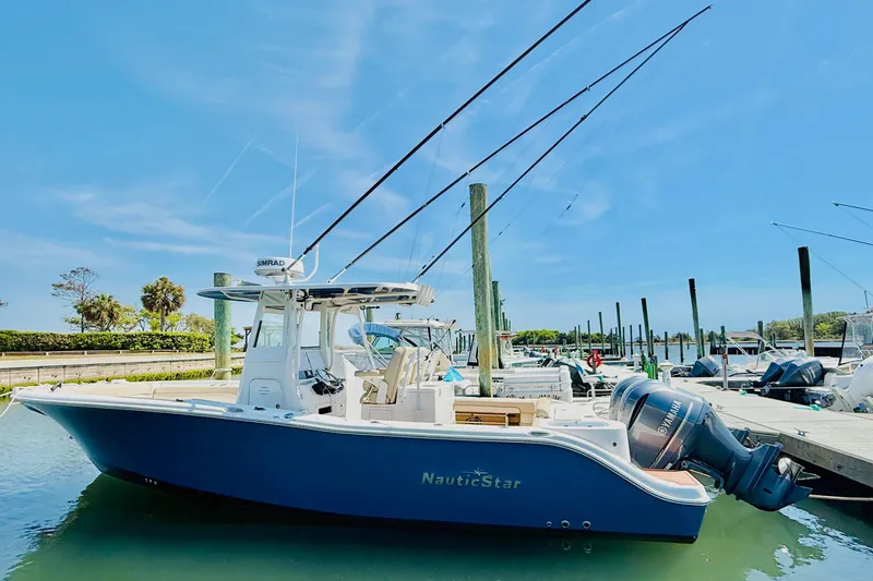 The Image of 2021 NauticStar 28 XS boat docked in sunny marina. - 1