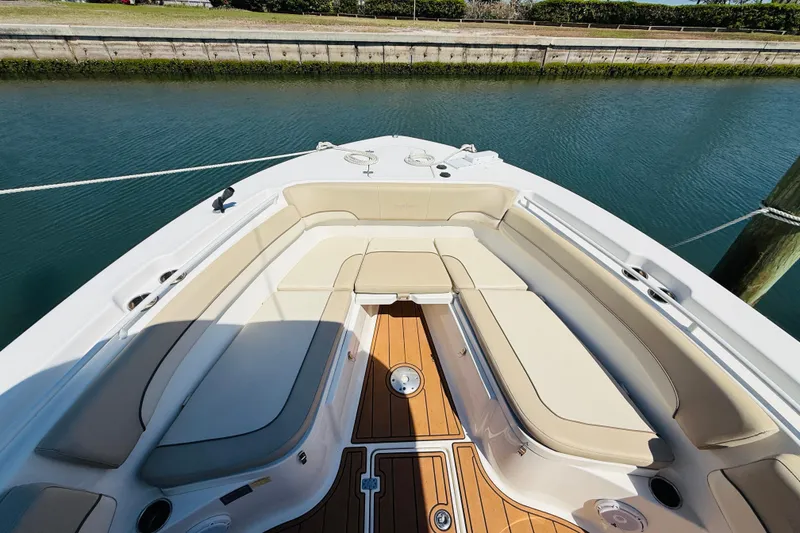 Slide: The Image of NauticStar 28 XS 2021 boat with luxurious seating area by the water. - 10