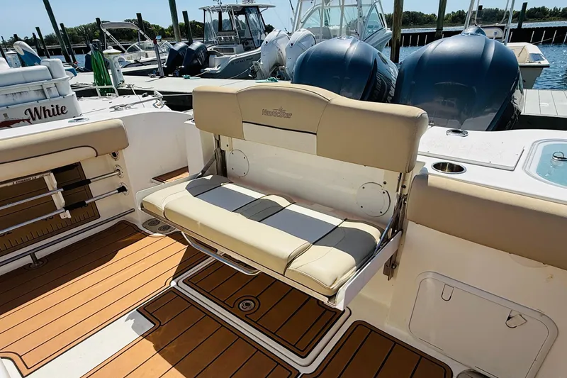 Slide: The Image of NauticStar 28 XS 2021 boat with beige seating and wood deck. - 7