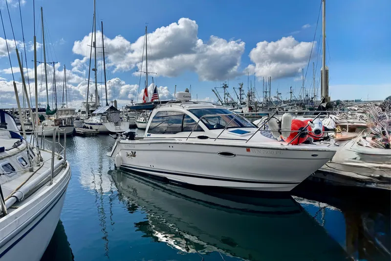 The Image of 2022 Cutwater boat docked in a marina under a blue sky with clouds. - 0