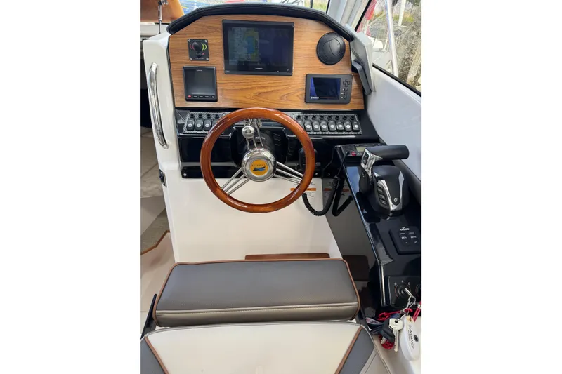 Slide: The Image of 2022 Cutwater boat helm with wooden dashboard, steering wheel, and navigation controls. - 5