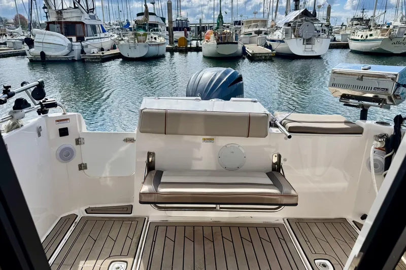 Slide: The Image of 2022 Cutwater boat interior with seating, docked at marina with yachts in background. - 6
