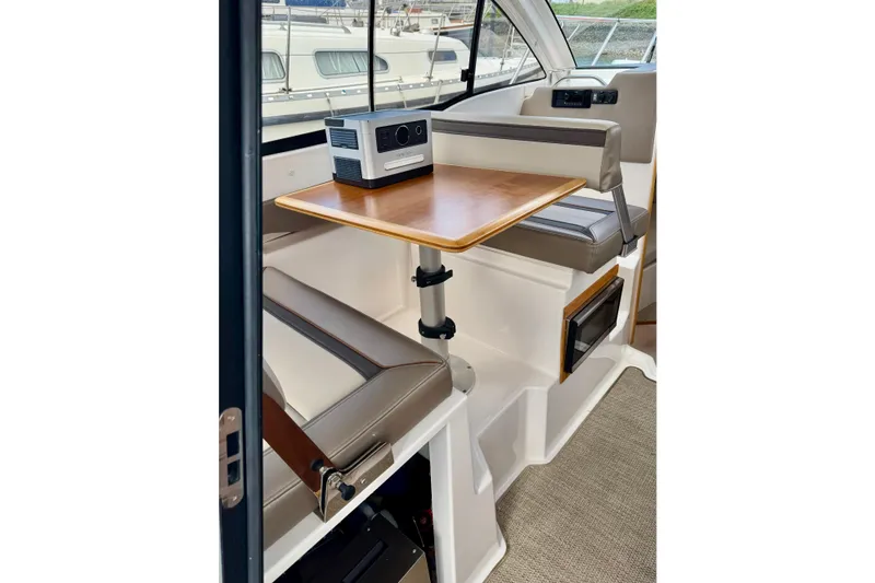 Slide: The Image of Interior of a 2022 Cutwater boat featuring a compact dining area with wooden table. - 7